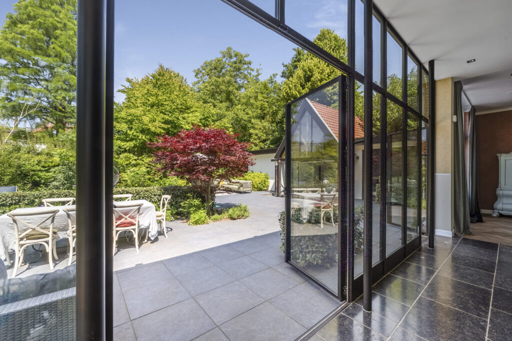 Open glass doors to garden patio dining area.