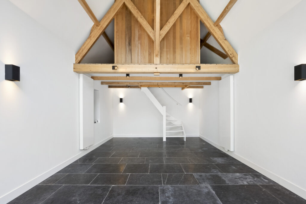 Modern loft with wooden beams and tiled floor.