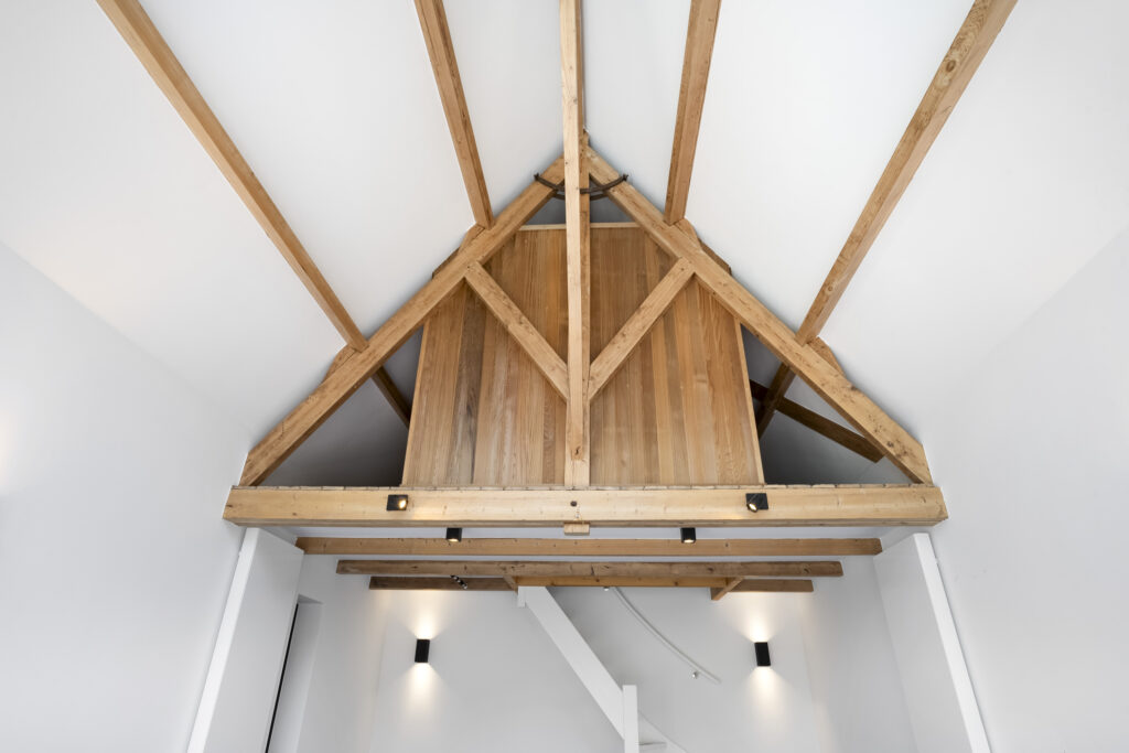 Wooden beams and loft in white interior room
