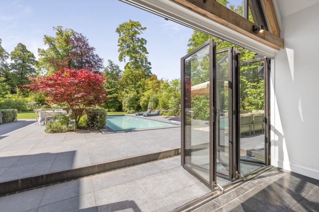 Open door to patio with pool and garden.