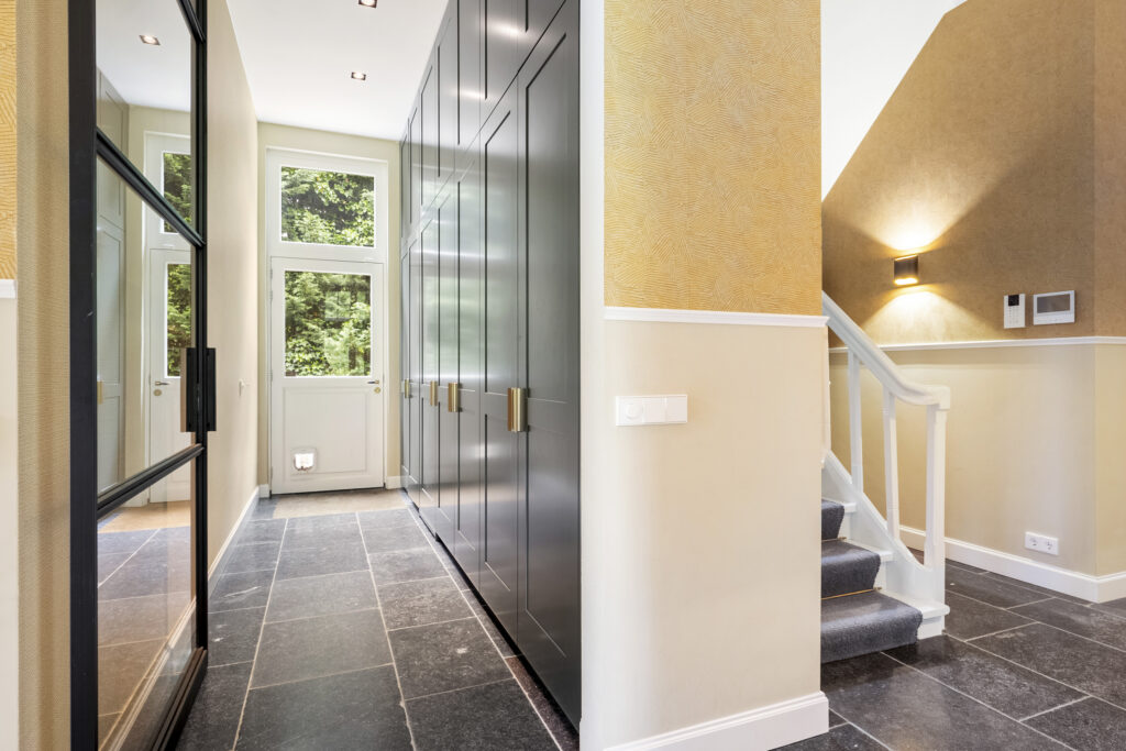 Modern hallway with black cabinets and staircase