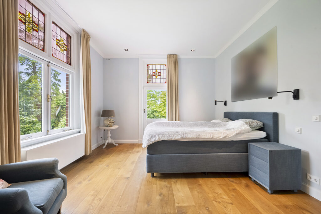 Bright bedroom with stained glass windows and modern decor.