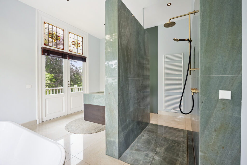 Luxurious bathroom with green tiles and modern shower.