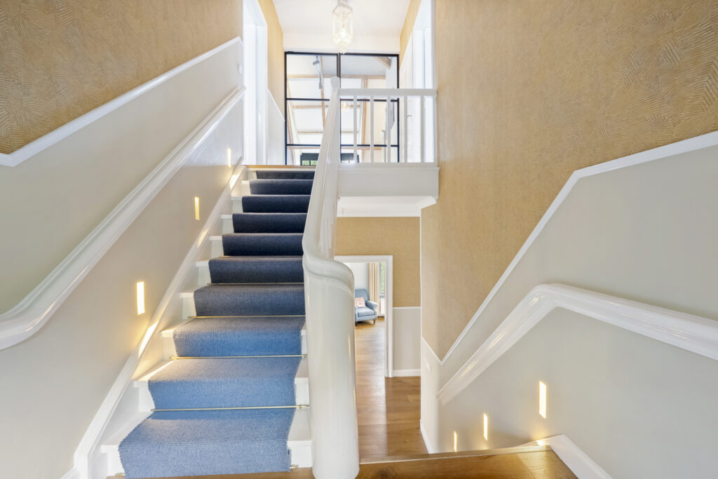Bright hallway with carpeted stairs and modern design.