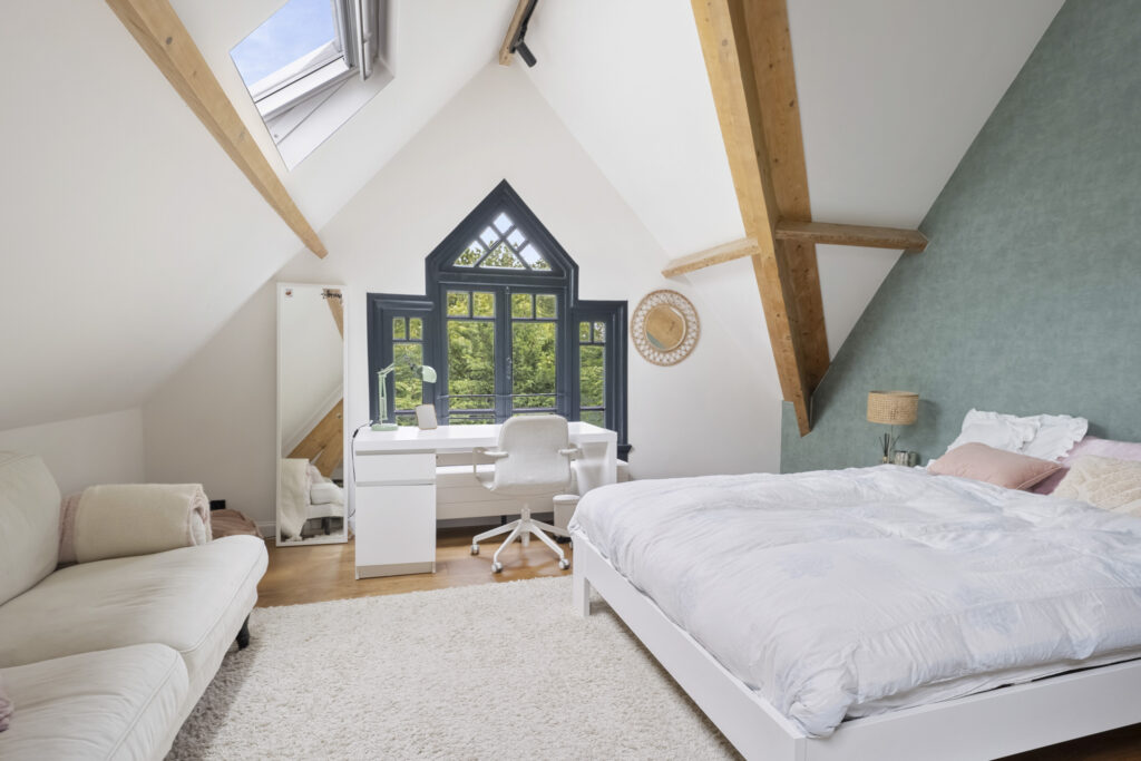 Cozy attic bedroom with desk and large window