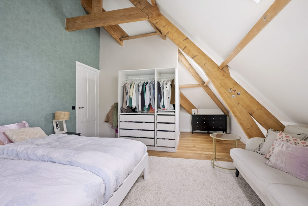 Cozy attic bedroom with exposed wooden beams.