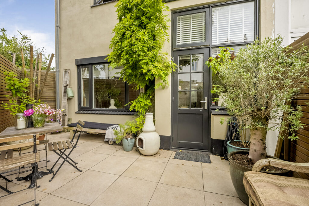 Cozy garden patio with plants and seating.