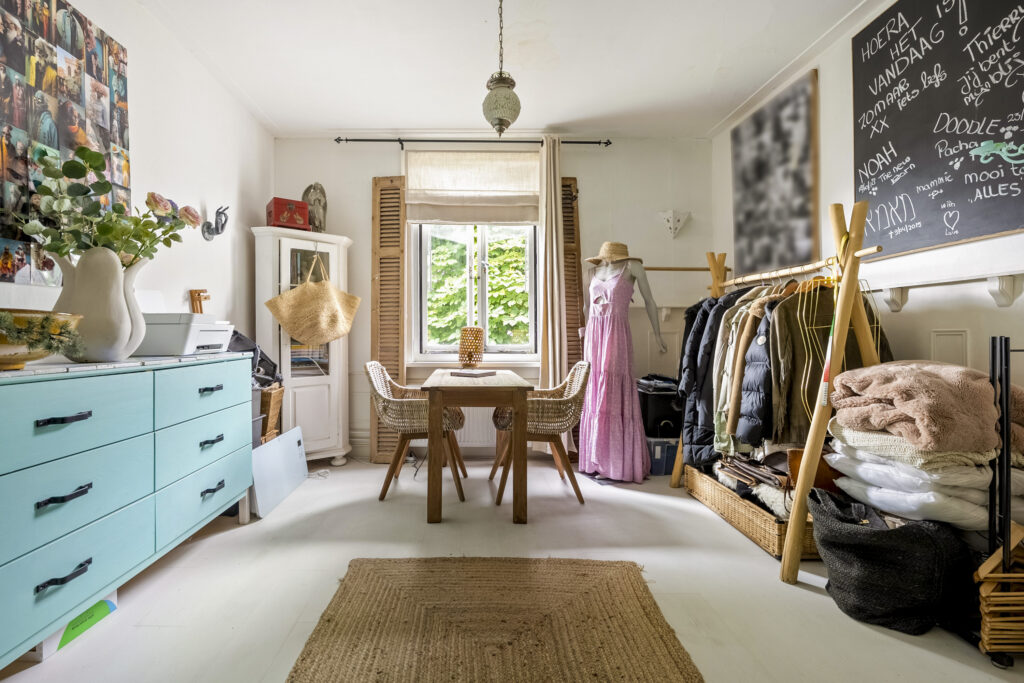 Cozy room with table, mannequin, clothes, and decor.
