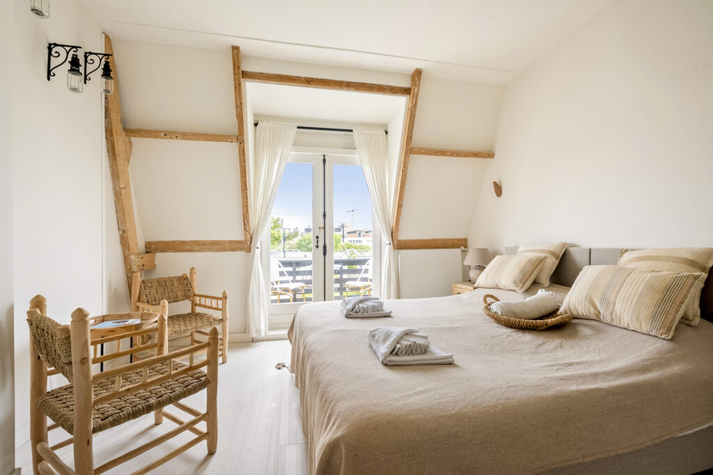 Cozy bedroom with wooden accents and balcony view.