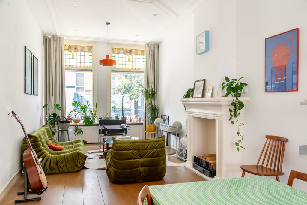 Cozy living room with green sofas and plants.