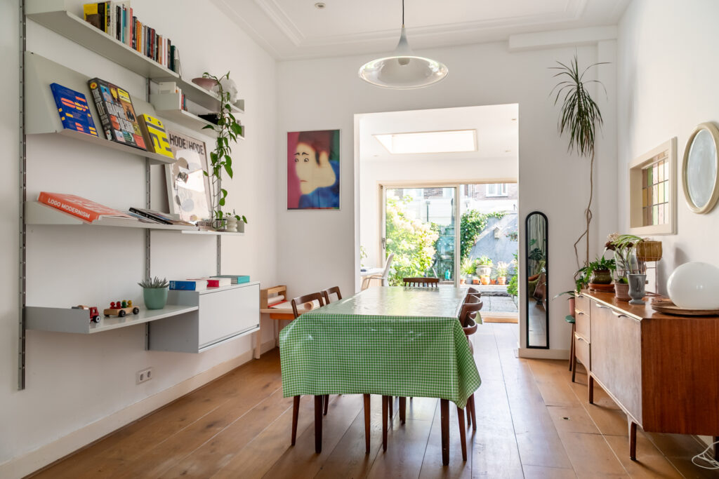 Bright dining room with plants and bookshelves