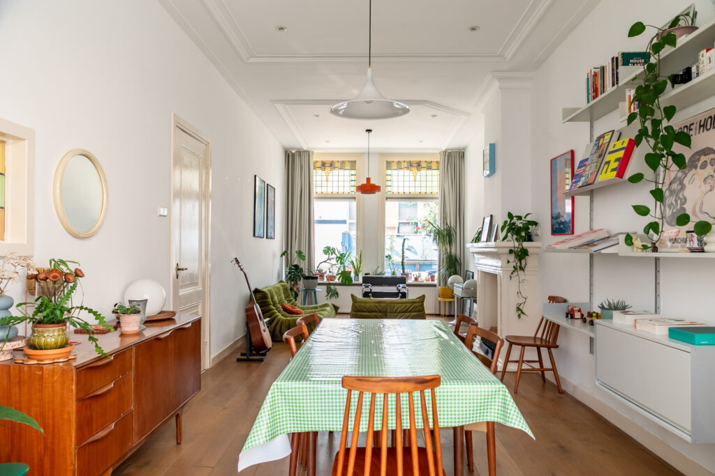 Bright dining room with plants and wooden furniture.