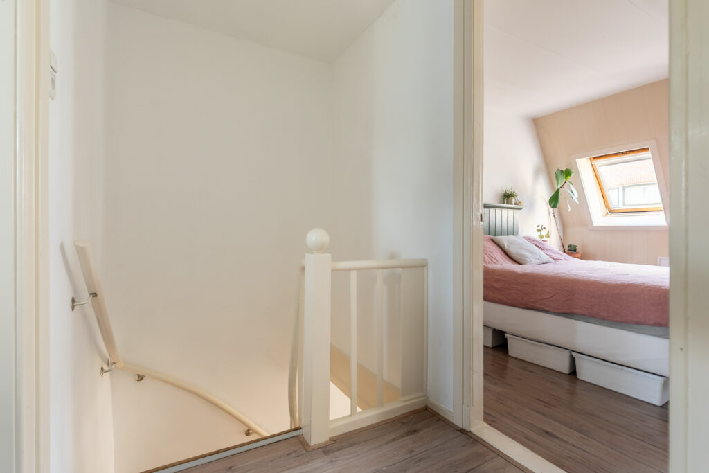Cozy bedroom with sloped ceiling and skylight window.