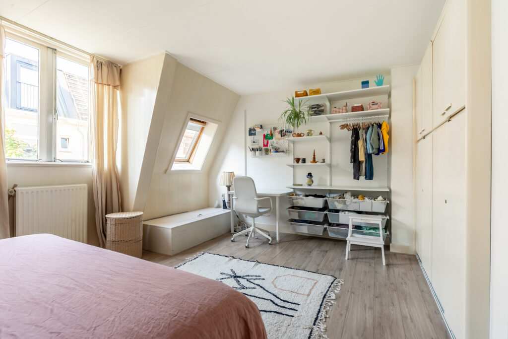 Cozy bedroom with desk and natural light.