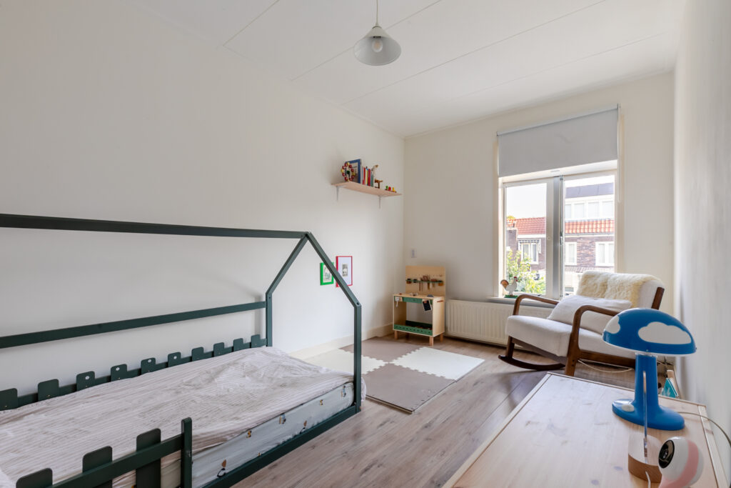 Minimalist child's bedroom with house-shaped bed.