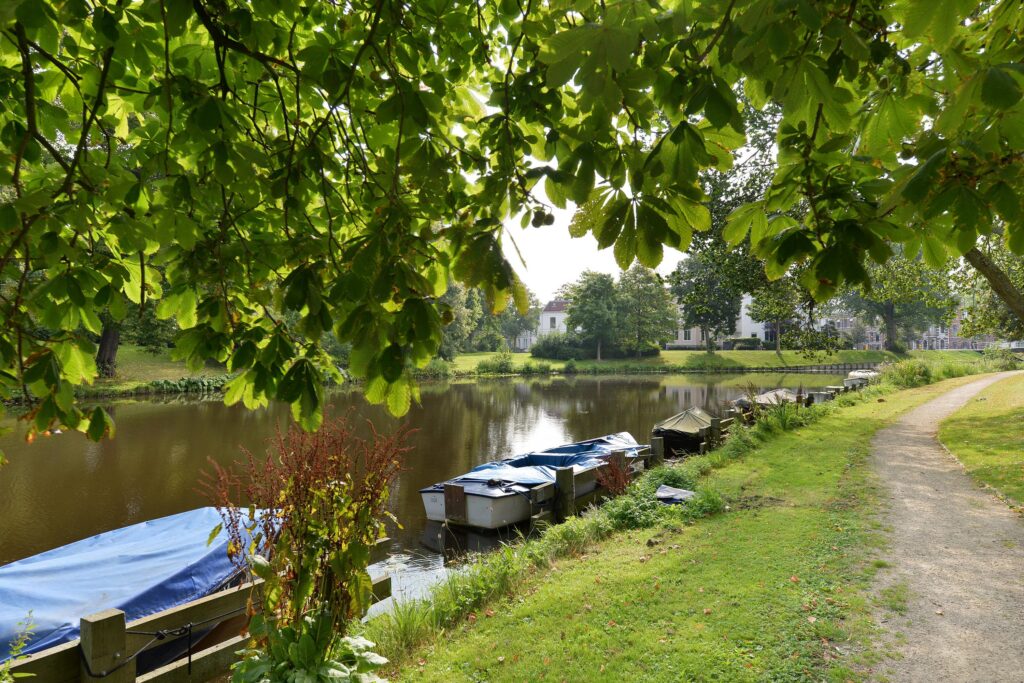 Lakeside with boats, trees, and a path.
