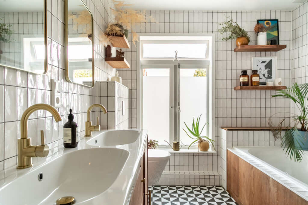 Modern bathroom with gold faucets and plants