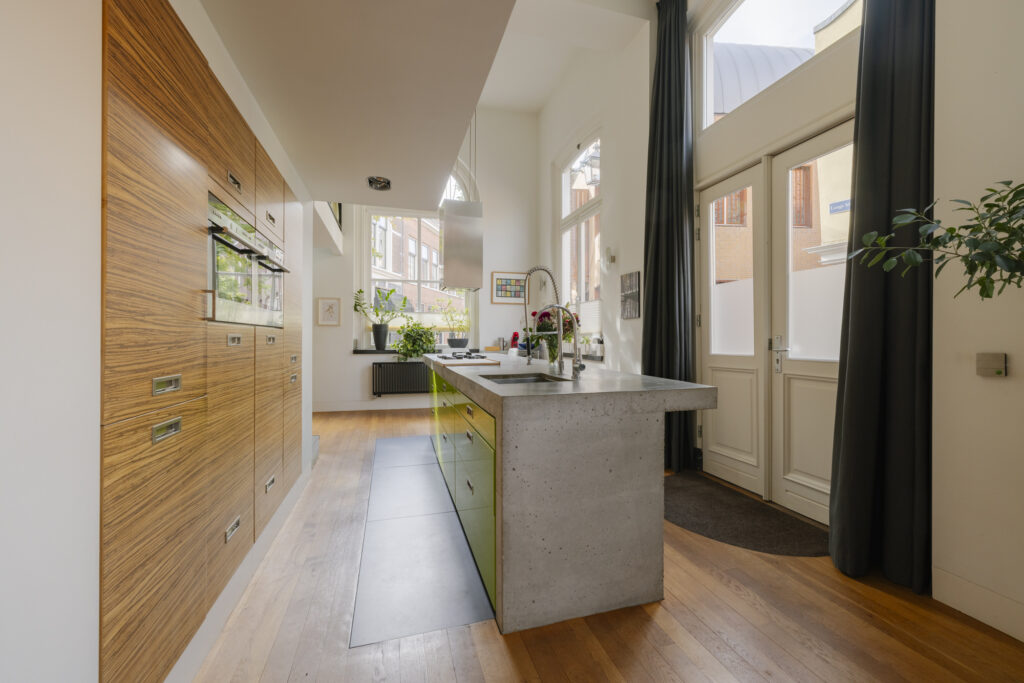 Modern kitchen with island and large windows.