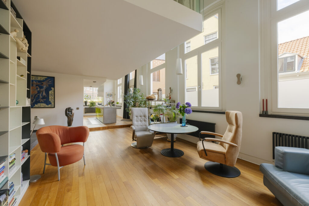 Modern living room with colorful chairs and plants.