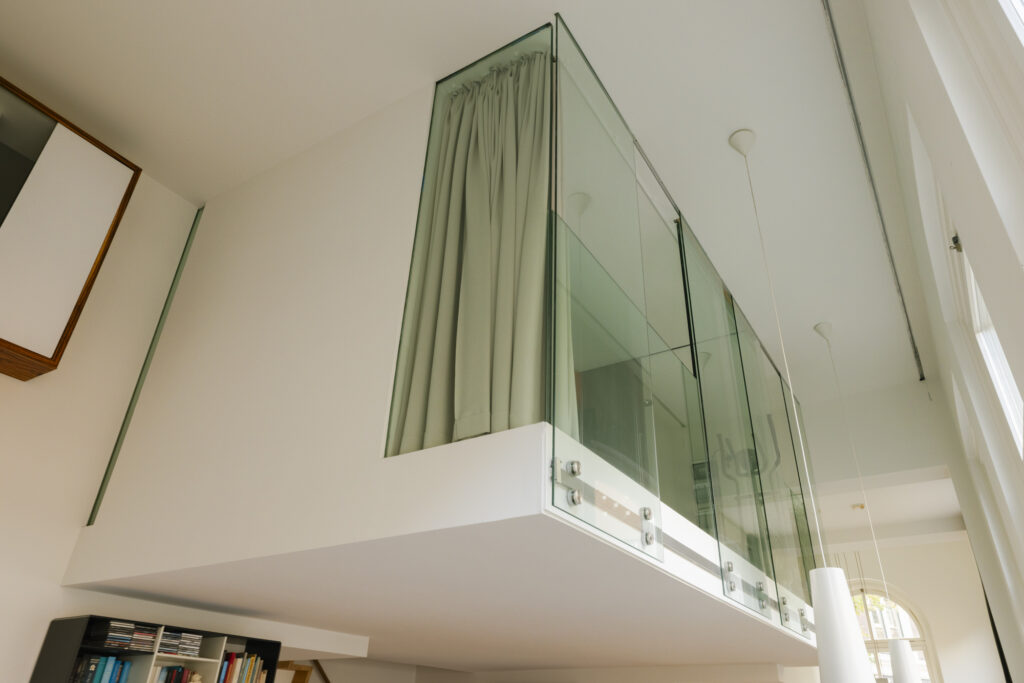 Modern loft space with glass partitions and bookshelf.