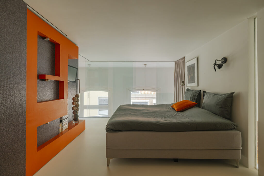Modern bedroom with orange accents and large window