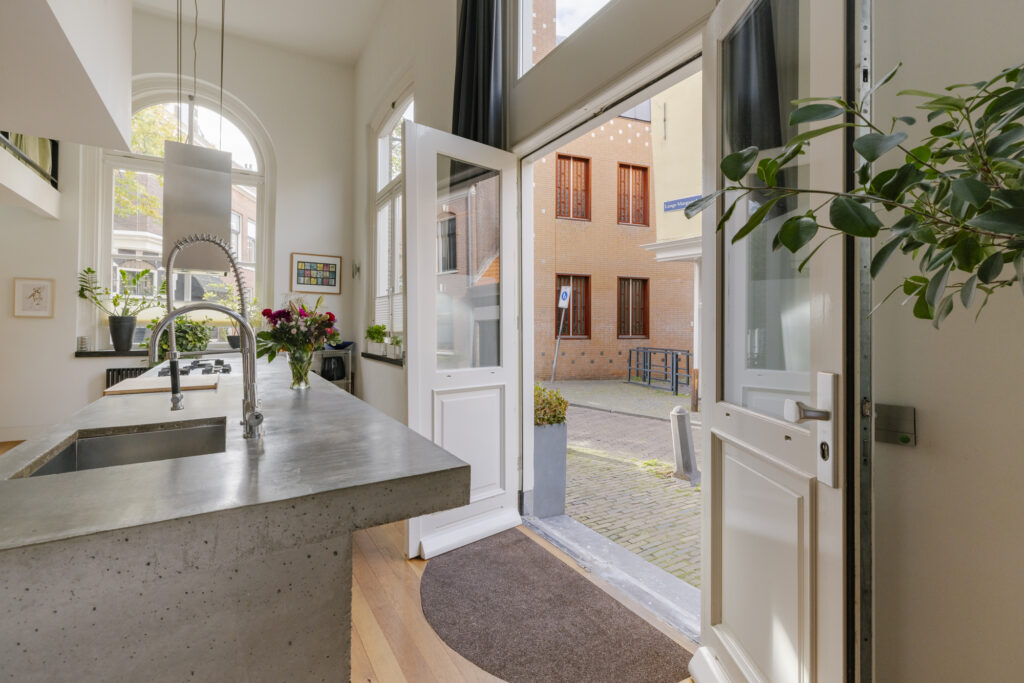 Modern kitchen with open door to courtyard.
