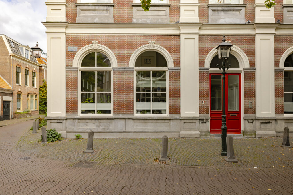Historic European brick building with red door.