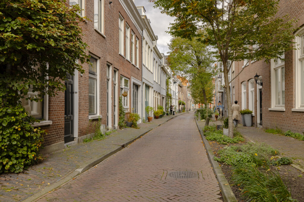 Charming European street with brick buildings and trees.