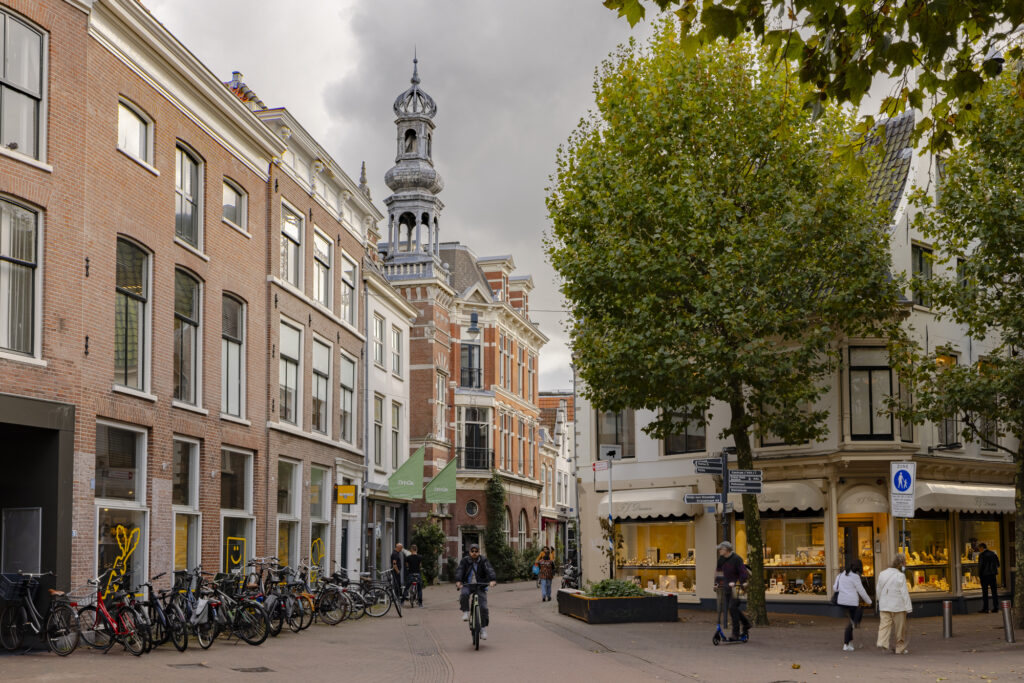 Bicycles and people in a historic European street scene.