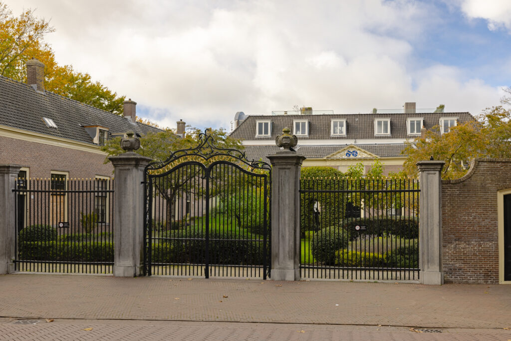 Historic gate with autumn foliage and building
