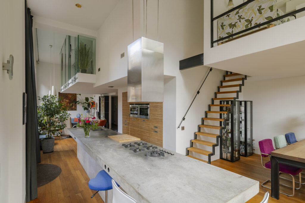 Modern kitchen with island, staircase, and seating area