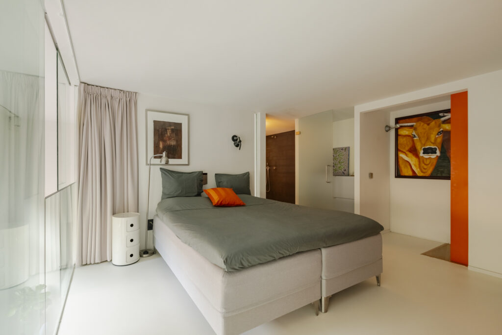 Modern bedroom with art and large bed.