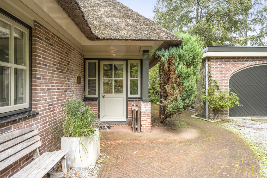 Charming house entrance with brick walkway and plants.