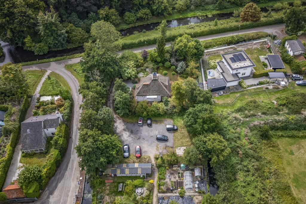 Aerial view of houses, trees, and gardens.