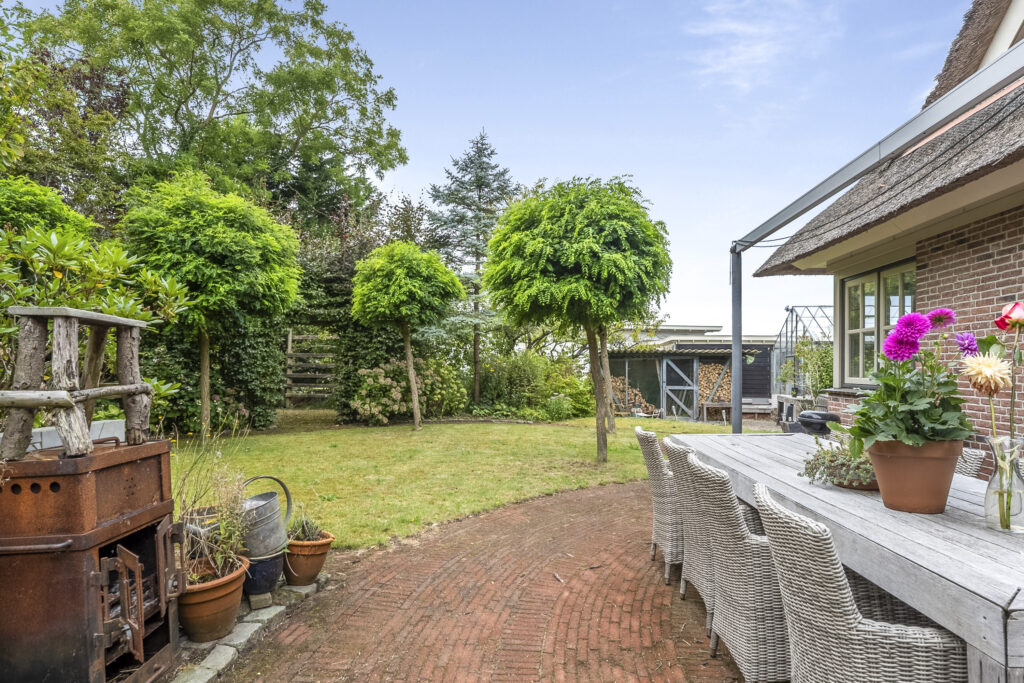 Charming garden with outdoor dining area and greenery.