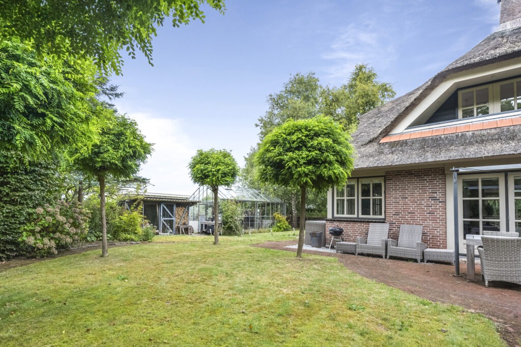 Cozy brick house with garden and patio furniture.