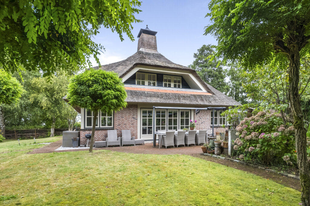 Charming brick house with thatched roof and garden