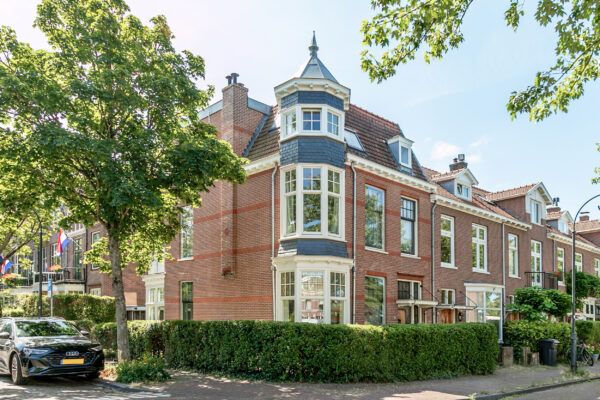 Charming corner building with trees, blue sky.