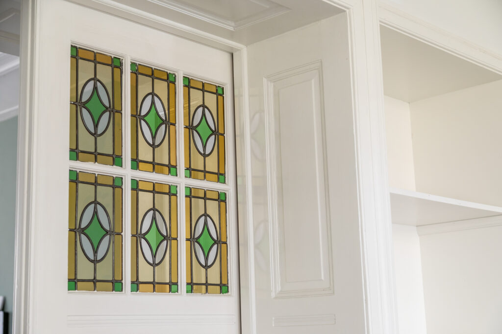 Decorative stained glass door in white frame.