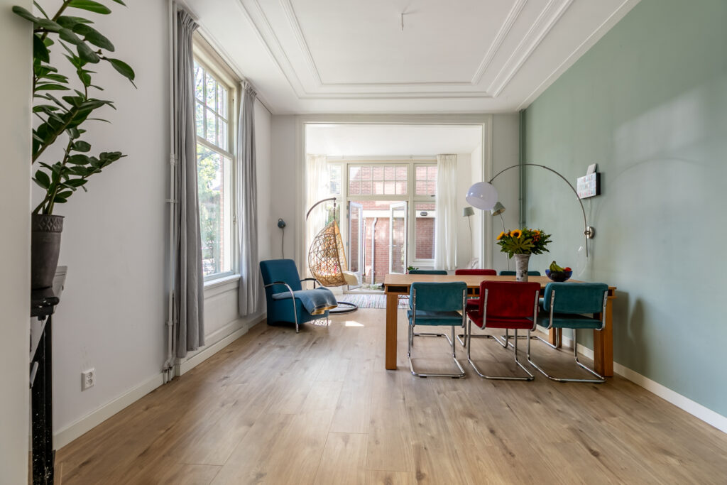 Modern dining room with colorful chairs and plants.