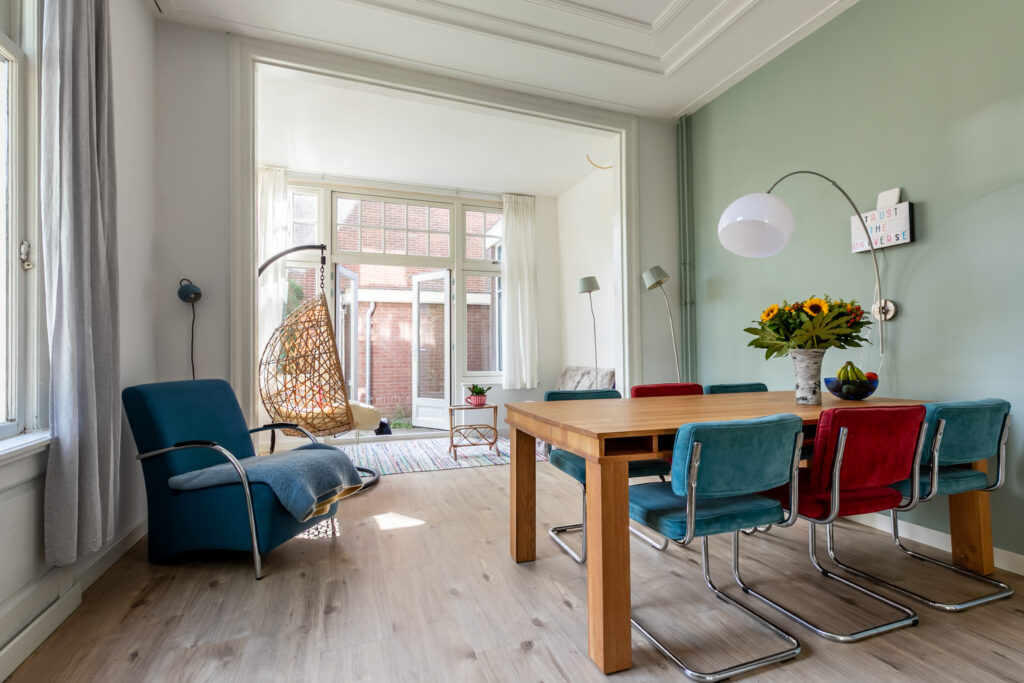 Modern dining room with colorful chairs and decor.