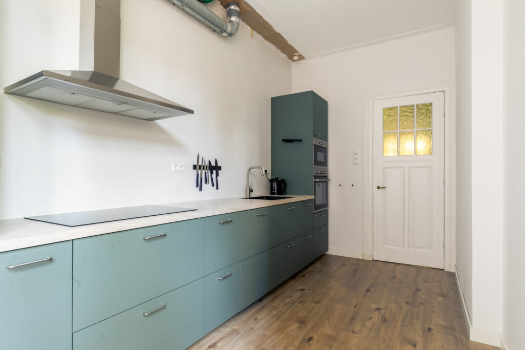 Modern kitchen with teal cabinets.