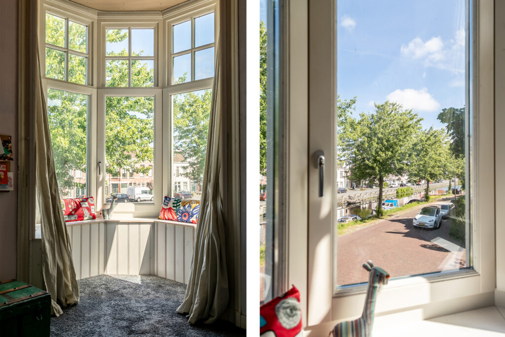 Bay window view with street and trees.