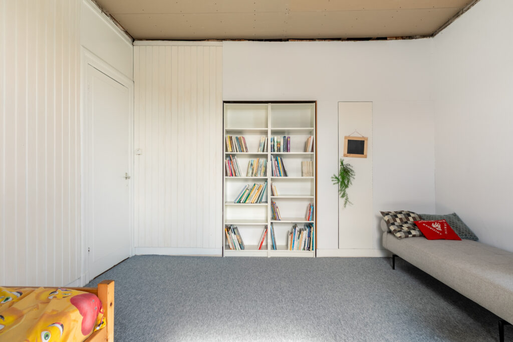 Minimalist room with bookshelf and daybed