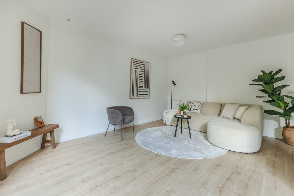 Minimalist living room with beige sofa and plants.