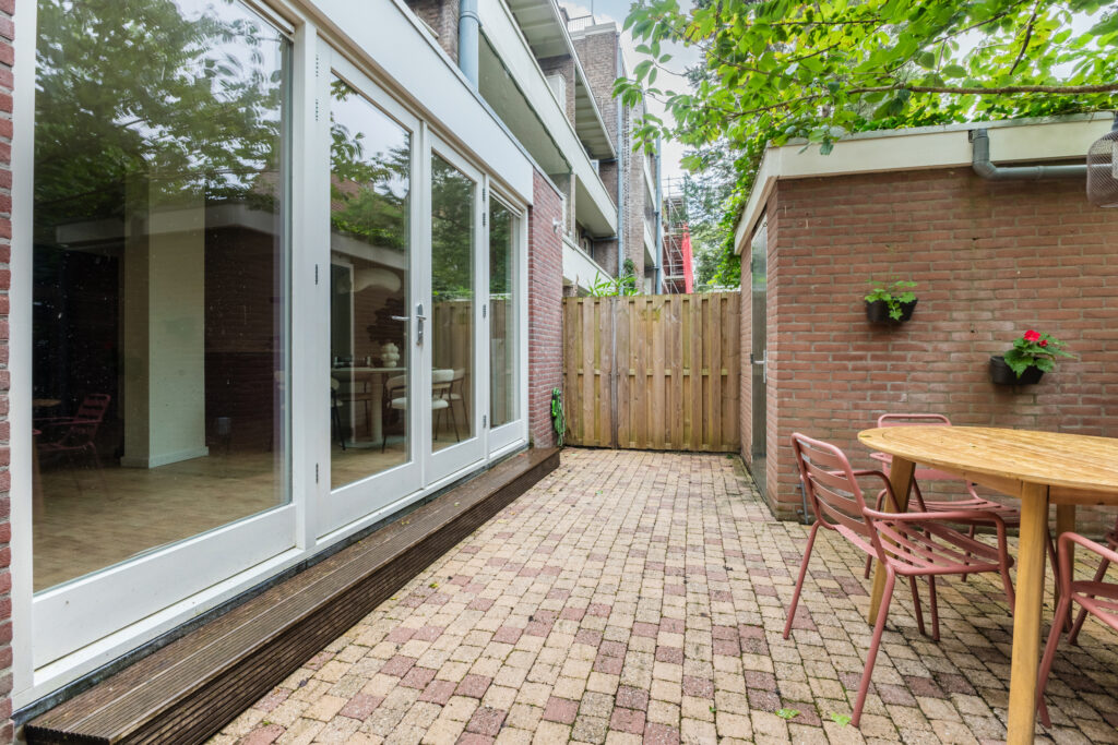 Patio with brick flooring and outdoor table.