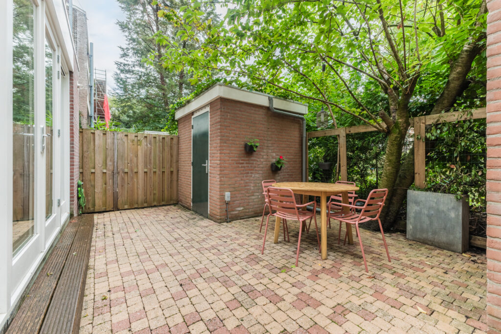 Brick patio with table, chairs, and garden shed.