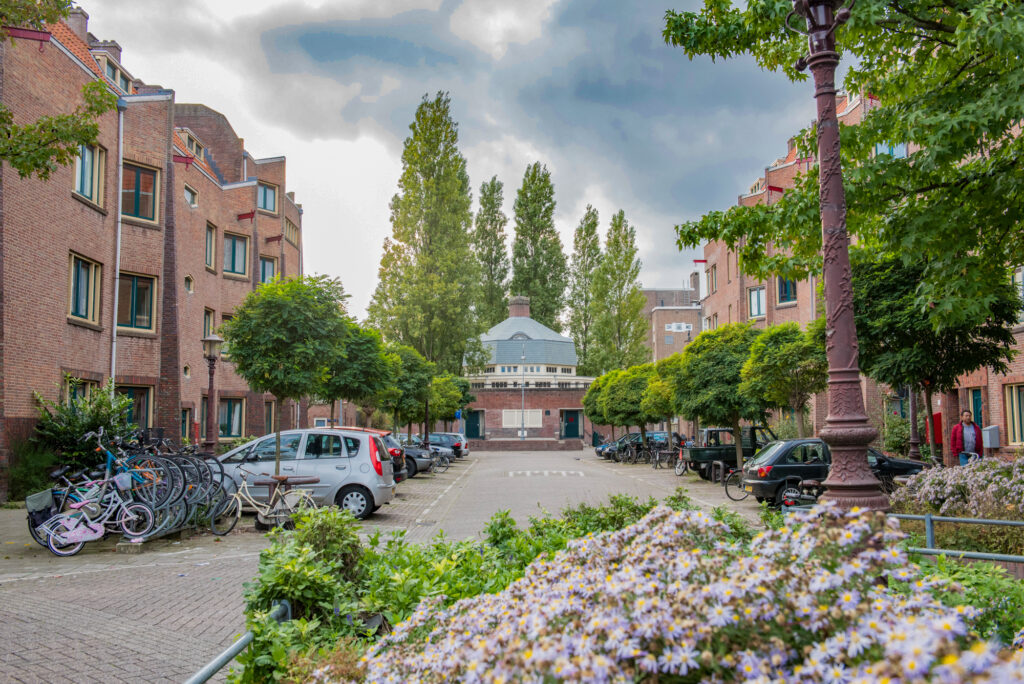 Urban street with bicycles and parked cars.