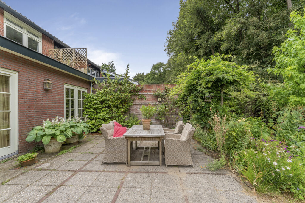 Charming backyard patio with garden and outdoor seating.