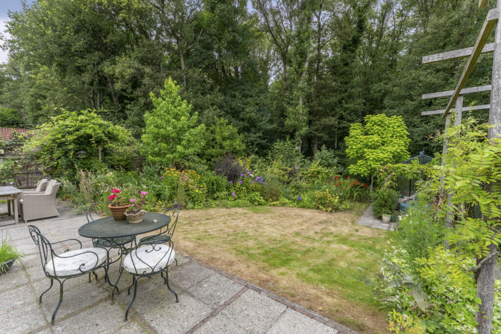 Lush garden with patio and seating area.